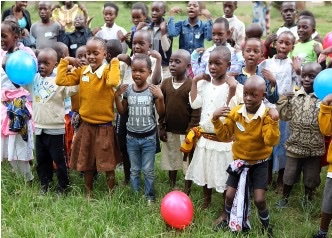 Tushinde Children's Trust: a group of children actively take part in a song or dance